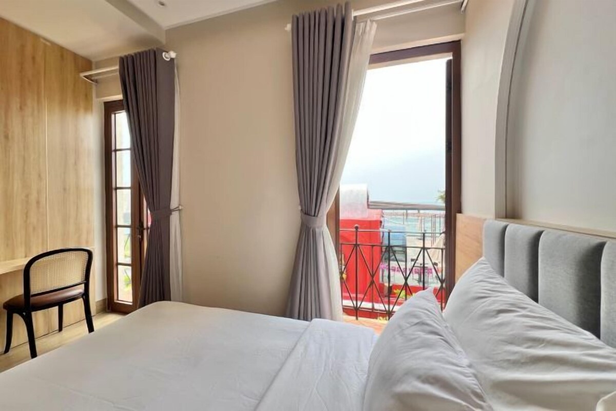 Une chambre d’hôtel avec un lit, une chaise et une fenêtre avec des rideaux.