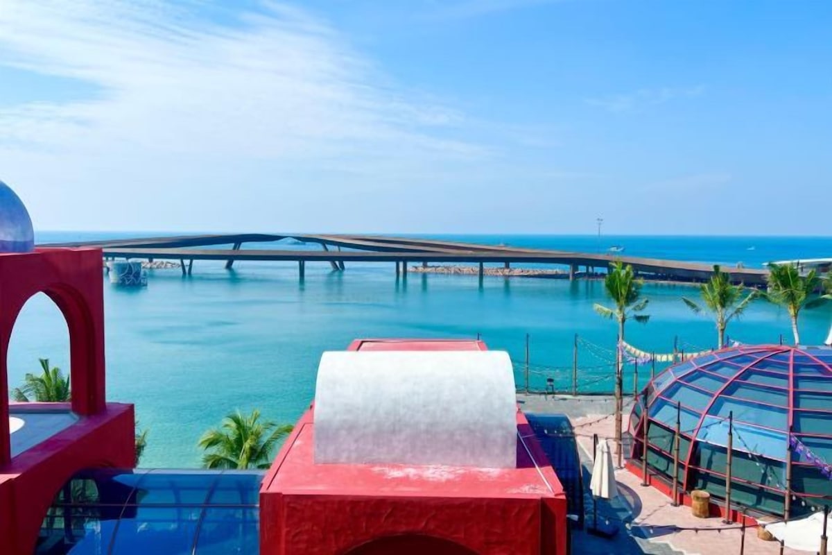 A resort with a water body, a bridge, and a dome structure.
