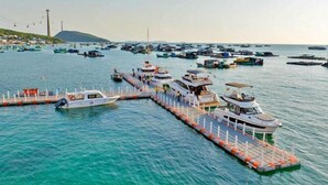 Un puerto deportivo con varias embarcaciones amarradas y un muelle que se adentra en el agua.
