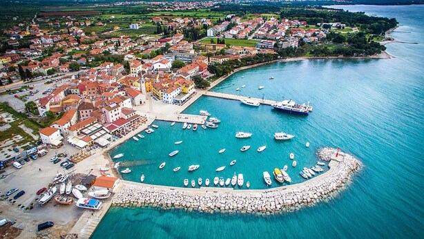 An aerial view of a coastal town with a marina, houses, and a large ship docked at the pier. - Awesome apartment in Fazana with swimming pool (Fazana)