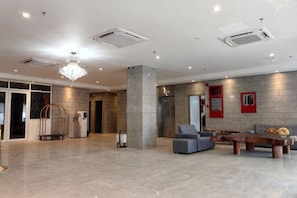 A spacious lobby with a chandelier, a reception desk, a seating area, and a wall-mounted elevator. - Forum Hotel Penang (George Town)