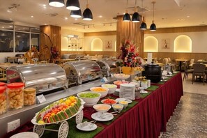 A buffet setup with various food items and a decorative centerpiece. - Forum Hotel Penang (George Town)