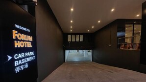 Un hall d’hôtel moderne avec un panneau indiquant l’accès au parking souterrain.
