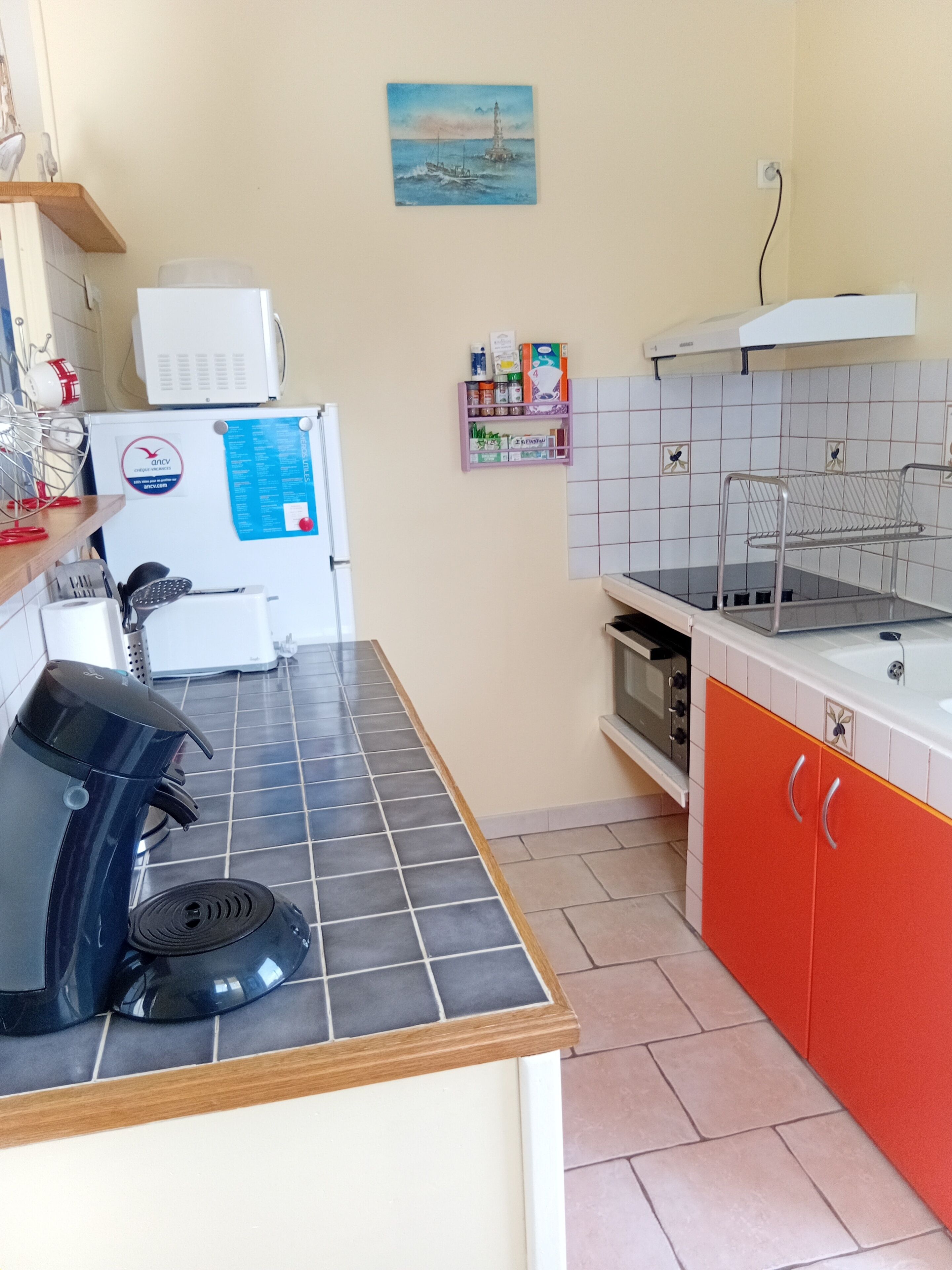 Une cuisine compacte équipée d’une machine à café, d’un four à micro-ondes, d’un petit four et d’un évier.