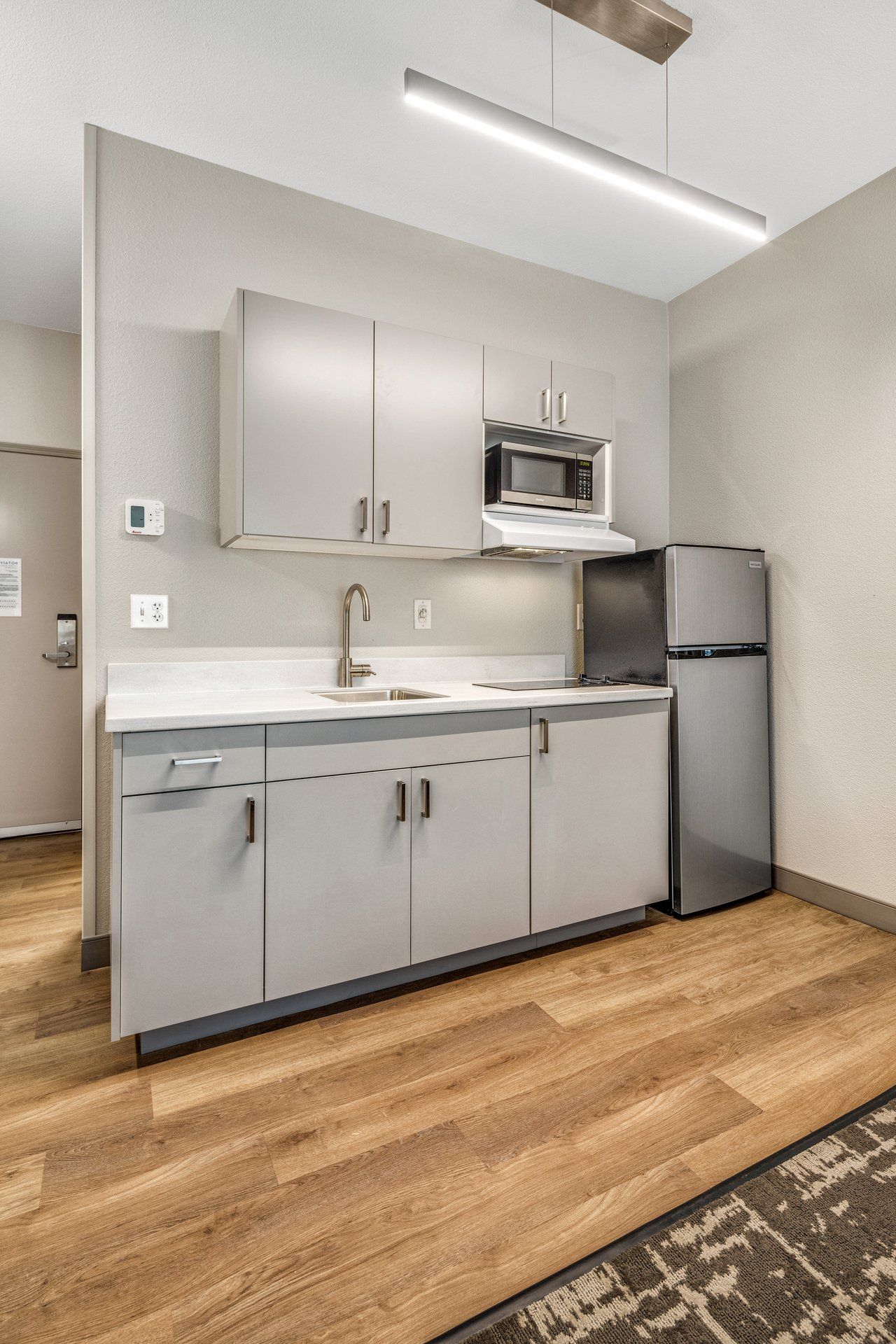 A modern kitchen with a stainless steel refrigerator, a microwave, and a built-in oven.