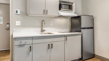 A modern kitchen with a stainless steel refrigerator, a microwave, and a built-in oven.