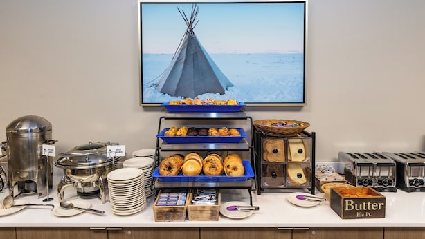 Een buffetopstelling met verschillende soorten eten, waaronder gebak, brood en boter.