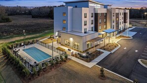 Ein modernes Hotel mit Pool, Außenbereich und Parkplatz.