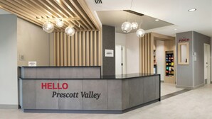 Un comptoir d’accueil avec une pancarte indiquant « BONJOUR Prescott Valley » et une autre pancarte, plus petite, au-dessus, sur laquelle est écrit « PINCH ».