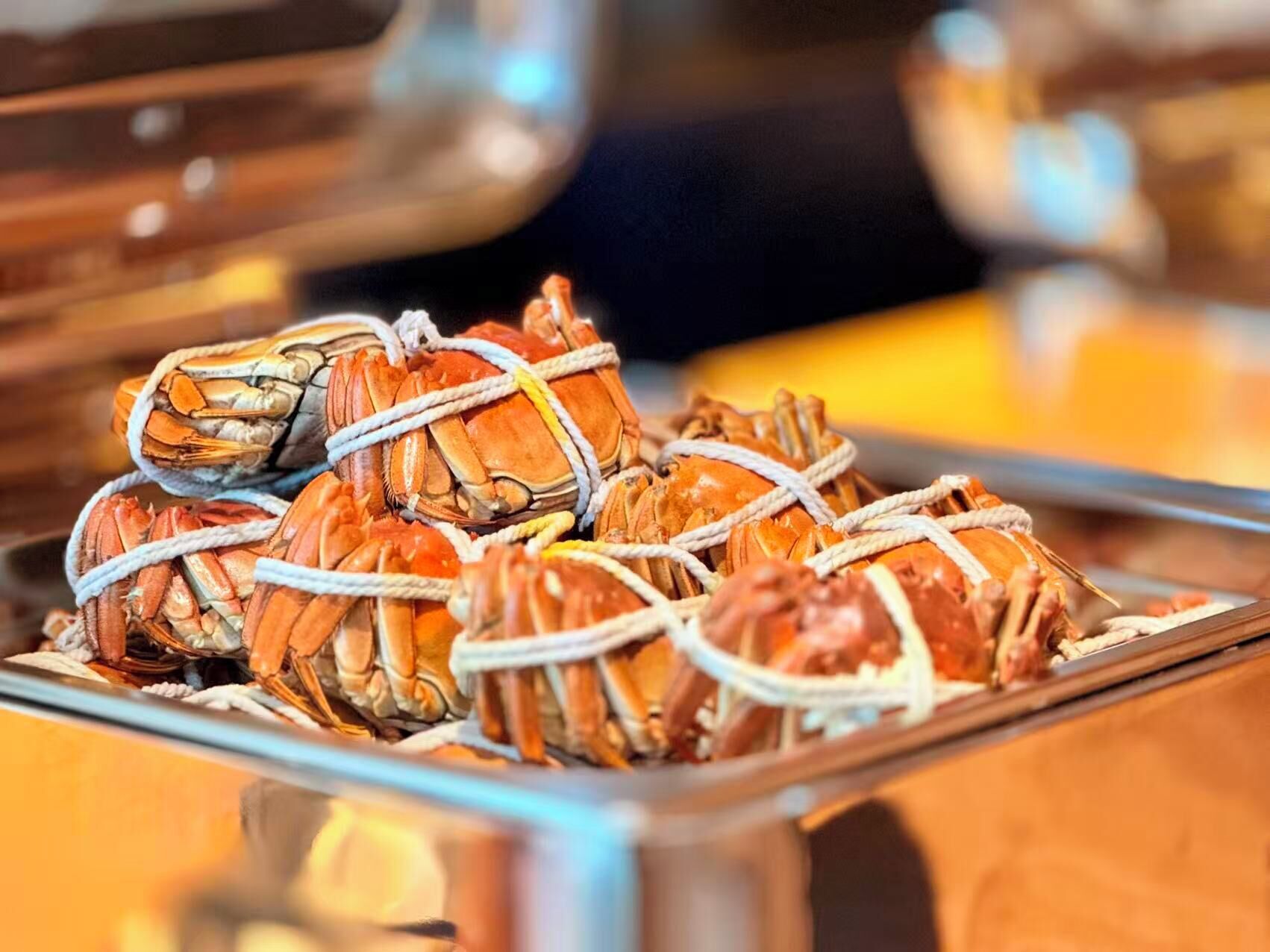 A tray of tied crabs, likely prepared for cooking or serving.