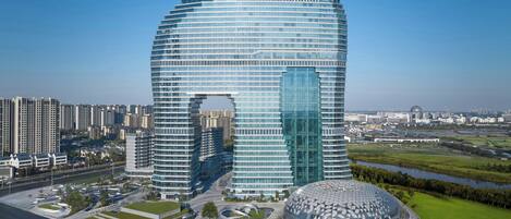 Un edificio moderno de varios pisos con una fachada de vidrio curva distintiva y un atrium central.