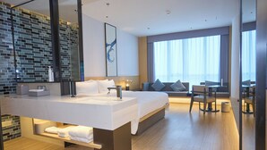 A modern hotel room with a large bed, a desk, and a bathroom with a large mirror and a sink. - Fairfield By Marriott Huzhou Nanxun (Huzhou)