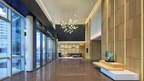 A spacious lobby with a modern chandelier, a reception desk, and a glass wall offering a view of the outside. - Fairfield By Marriott Huzhou Nanxun (Huzhou)