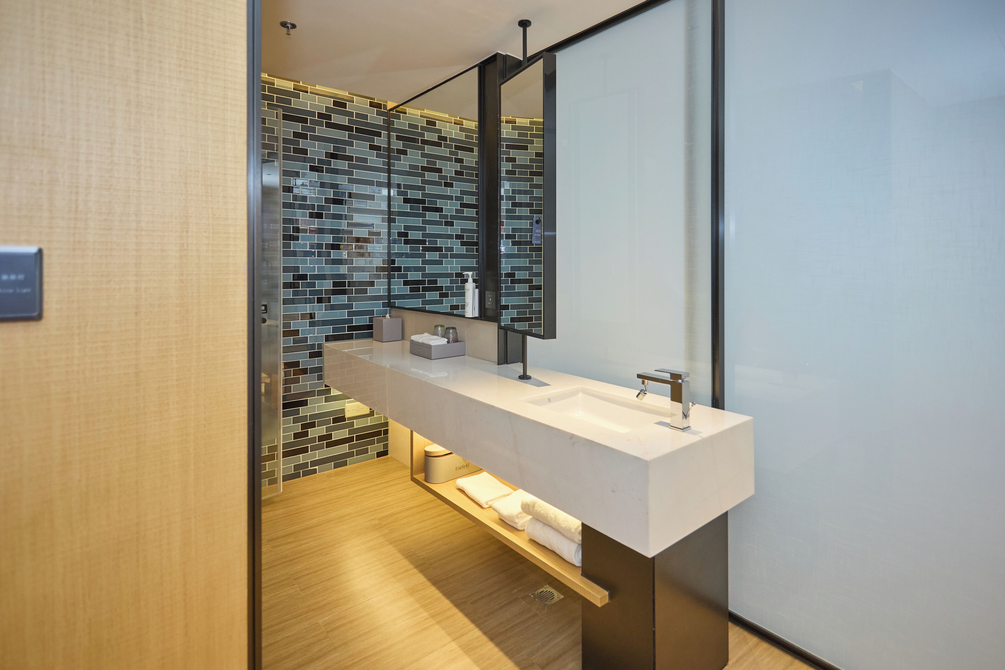 Un baño moderno con un tocador amplio, un espejo y un salpicadero de azulejos.