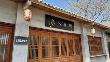 A traditional building with wooden doors and a signboard.