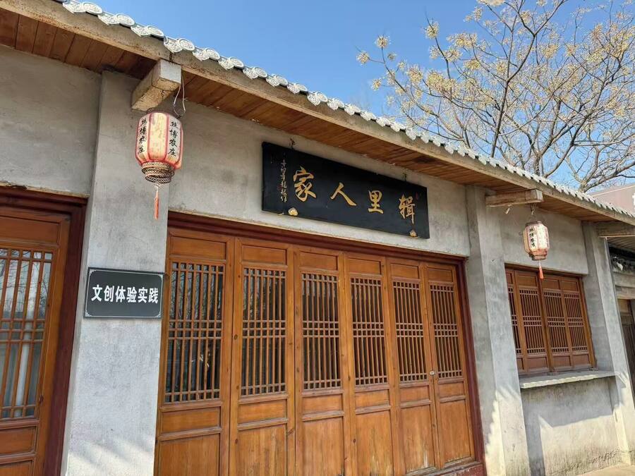 A traditional building with wooden doors and a signboard.