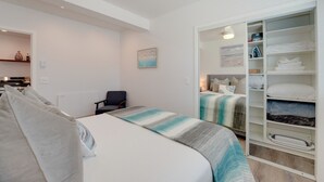 A bedroom with a bed, a chair, a wardrobe, and a painting on the wall. - Updated 1BR in Point Loma – Near Harbor & Airport (San Diego)