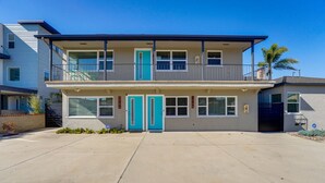 A two-story residential building with a balcony on the upper floor, a garage door, and a driveway. - Updated 1BR in Point Loma – Near Harbor & Airport (San Diego)