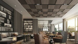 Un interior moderno con un sofá seccional, sillones, una mesa de centro y una zona de bar con estantes llenos de botellas.
