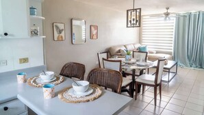 Een eetgedeelte met een ronde tafel, stoelen en een buffetopstelling.