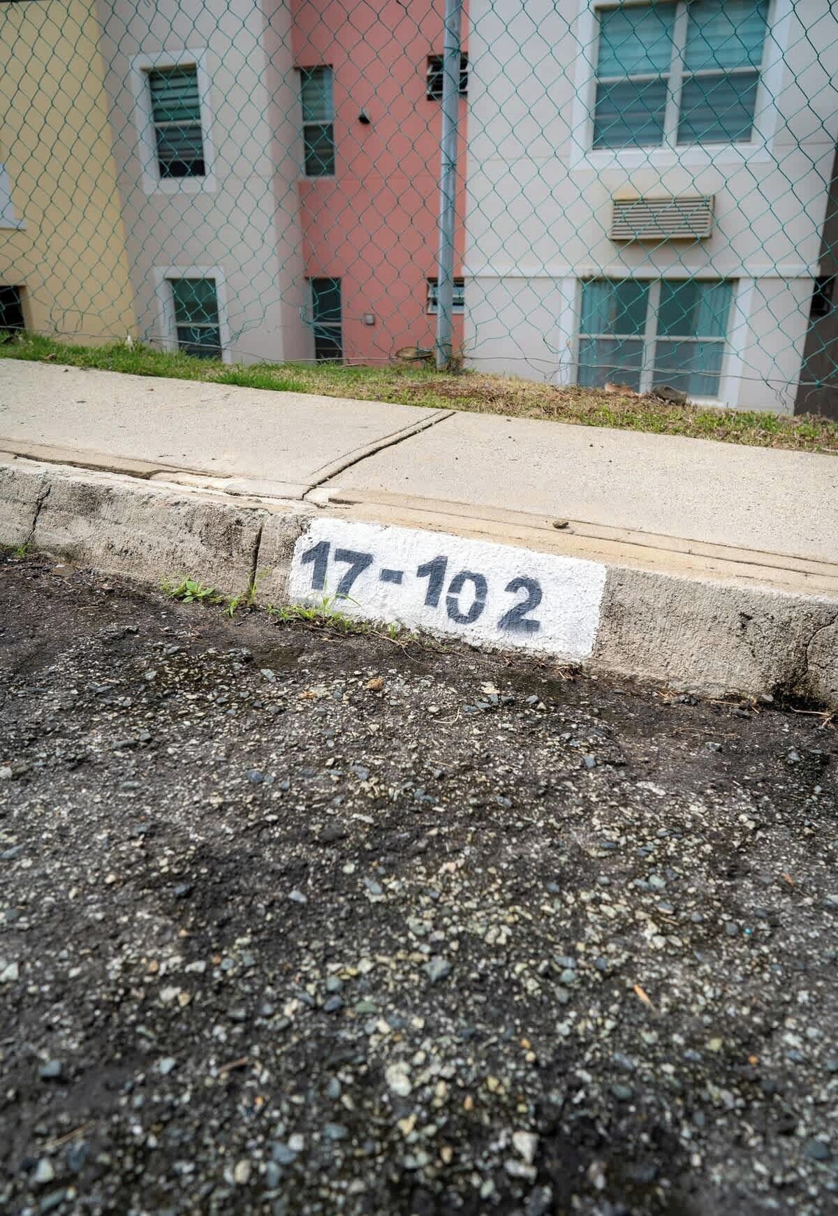 A parking lot with a concrete curb and a sign reading "17-102".