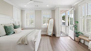 Ein Schlafzimmer mit Bett, Spiegel und einer Bank am Fenster.