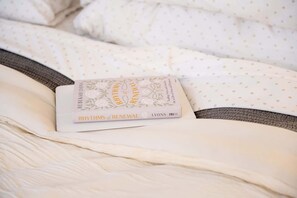 A book titled 'Rhythms of Renewal' by Rebekah Lyons placed on a bed with white bedding and a brown headboard. - Blü Zen, Ideal Couples Stay in Mameyes Rio Grande (Río Grande)