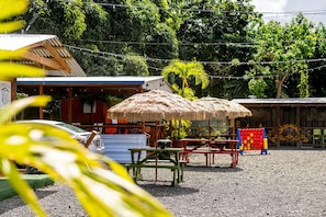 A building with a corrugated metal roof, a signboard, and a thatched umbrella. - Blü Zen, Ideal Couples Stay in Mameyes Rio Grande (Río Grande)