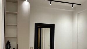 Ett modernt sovrum med en stor säng, en garderob och en spegel.