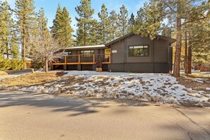 A cabin with a covered porch, a brick foundation, and a snow-covered ground. - Shadow Wood Lodge, w Hot Tub near Ski Slopes (Big Bear Lake)