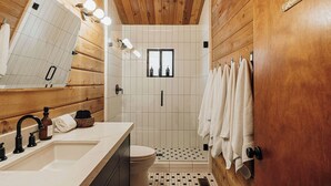A wooden cabin bathroom with a sink, mirror, and towel rack. - Shadow Wood Lodge, w Hot Tub near Ski Slopes (Big Bear Lake)