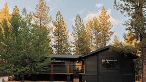 A cabin with a deck, surrounded by trees. - Shadow Wood Lodge, w Hot Tub near Ski Slopes (Big Bear Lake)