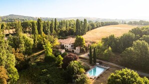A villa with a swimming pool surrounded by lush greenery and a hilly landscape in the background. - House in Reillanne With Pool & Nature Views (Reillanne)