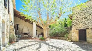 A courtyard with a tree, stone walls, and a rustic building. - House in Reillanne With Pool & Nature Views (Reillanne)