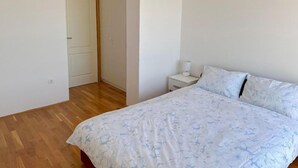 Une chambre à coucher avec un lit, une table de chevet et une porte.