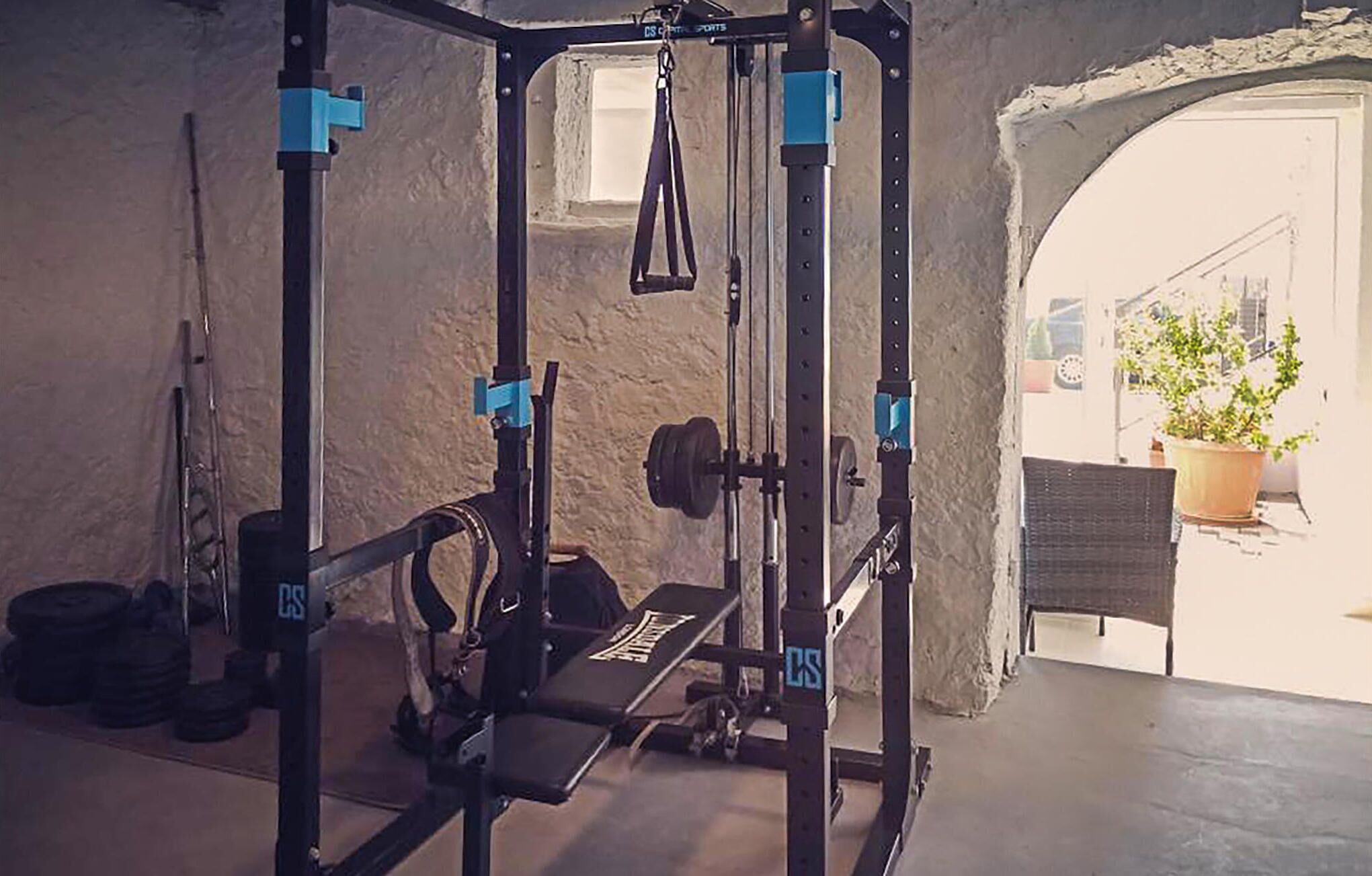 Ein Heimfitnessraum mit Squat-Rack, Bank und Gewichten.