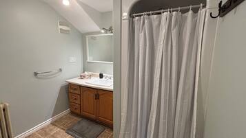 Een douche, handdoeken, zeep, toiletpapier