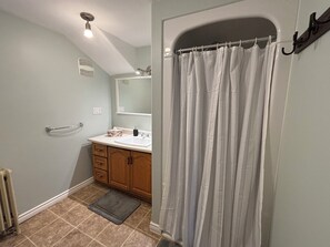 Een douche, handdoeken, zeep, toiletpapier