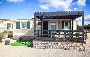 A mobile home with a covered porch, stone foundation, and green shutters. - Beautiful (sta)caravan in Drnis with WiFi (Drnis)
