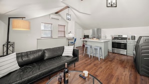 Un loft moderno con sala de estar, kitchenette y comedor.