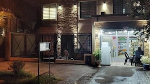 Un edificio con fachada de piedra, entrada porticada y escaparate visible.
