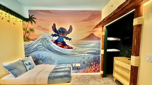 Una camera da letto con un murale raffigurante Stitch che fa surf, un letto con coperta a righe grigio e bianco e un comò in legno.