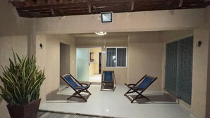 A covered outdoor seating area with two lounge chairs and a potted plant. - Exclusive Condominium Home - Resort Style Living with Pool and Parks 🌴🏊‍♂️ (Santa Cruz de la Sierra)