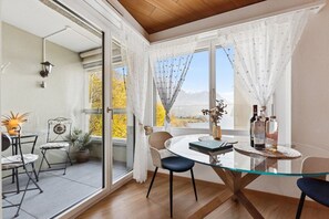 A dining area with a glass table, chairs, and a view of the outdoors.