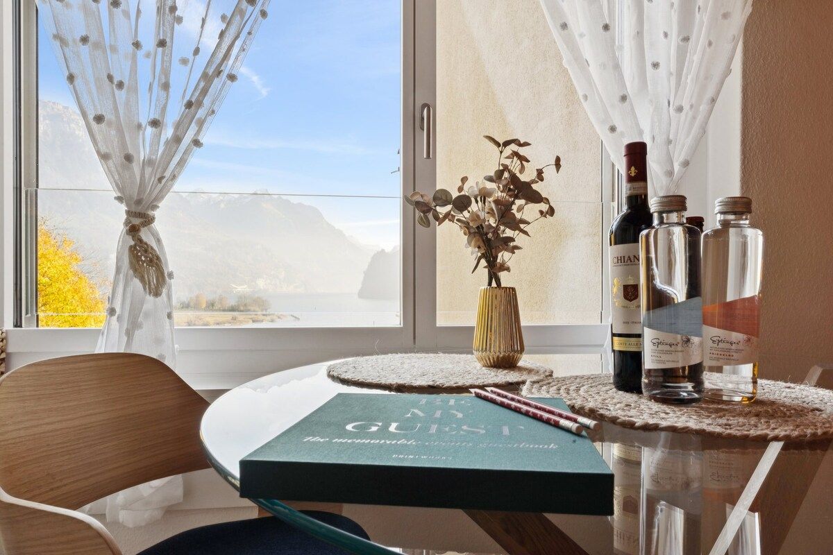 A table with a book titled 'The Memory Book,' a vase with dried flowers, and three bottles of wine.