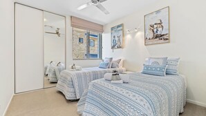 Un dormitorio con dos camas, un espejo grande y obras de arte en las paredes.