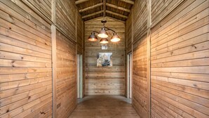 Ein Holzbodenkorridor mit schrägem Dach und Pendelleuchten.