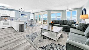 Un salon moderne avec un canapé gris, une table basse et un tapis.