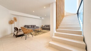 A modern living room with a staircase leading to an upper floor. - Villa Alimea Di San Ciprianu (sainte lucie de porto vecchio)