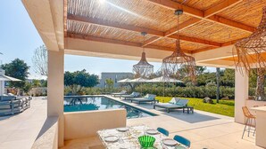 An outdoor dining area with a pool view, covered patio, and lounge chairs. - Villa Alimea Di San Ciprianu (sainte lucie de porto vecchio)